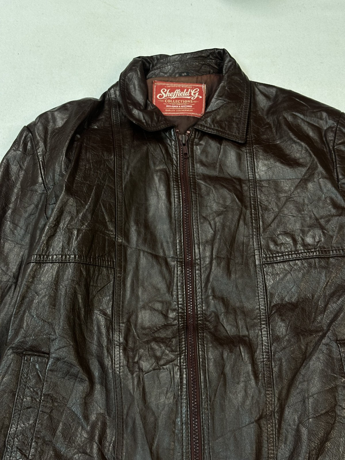Band collar and zip head on the burgundy leather bomber jacket