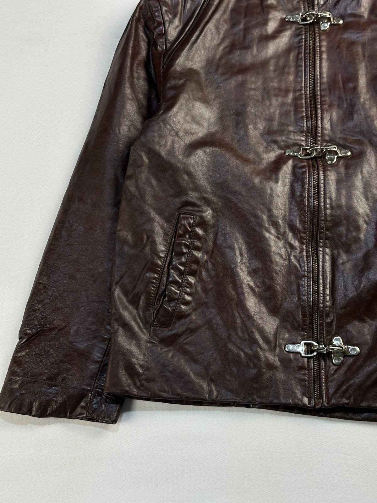 Close view of the leather grain and stitching on the burgundy jacket