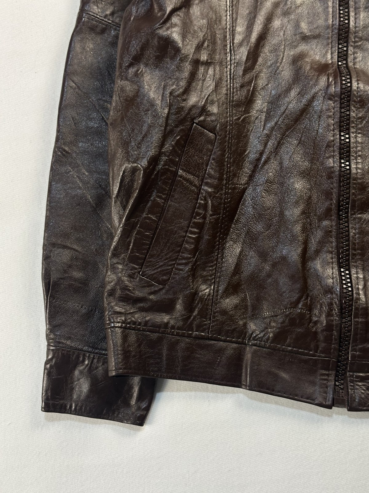 Close view of the leather grain and stitching on the burgundy jacket