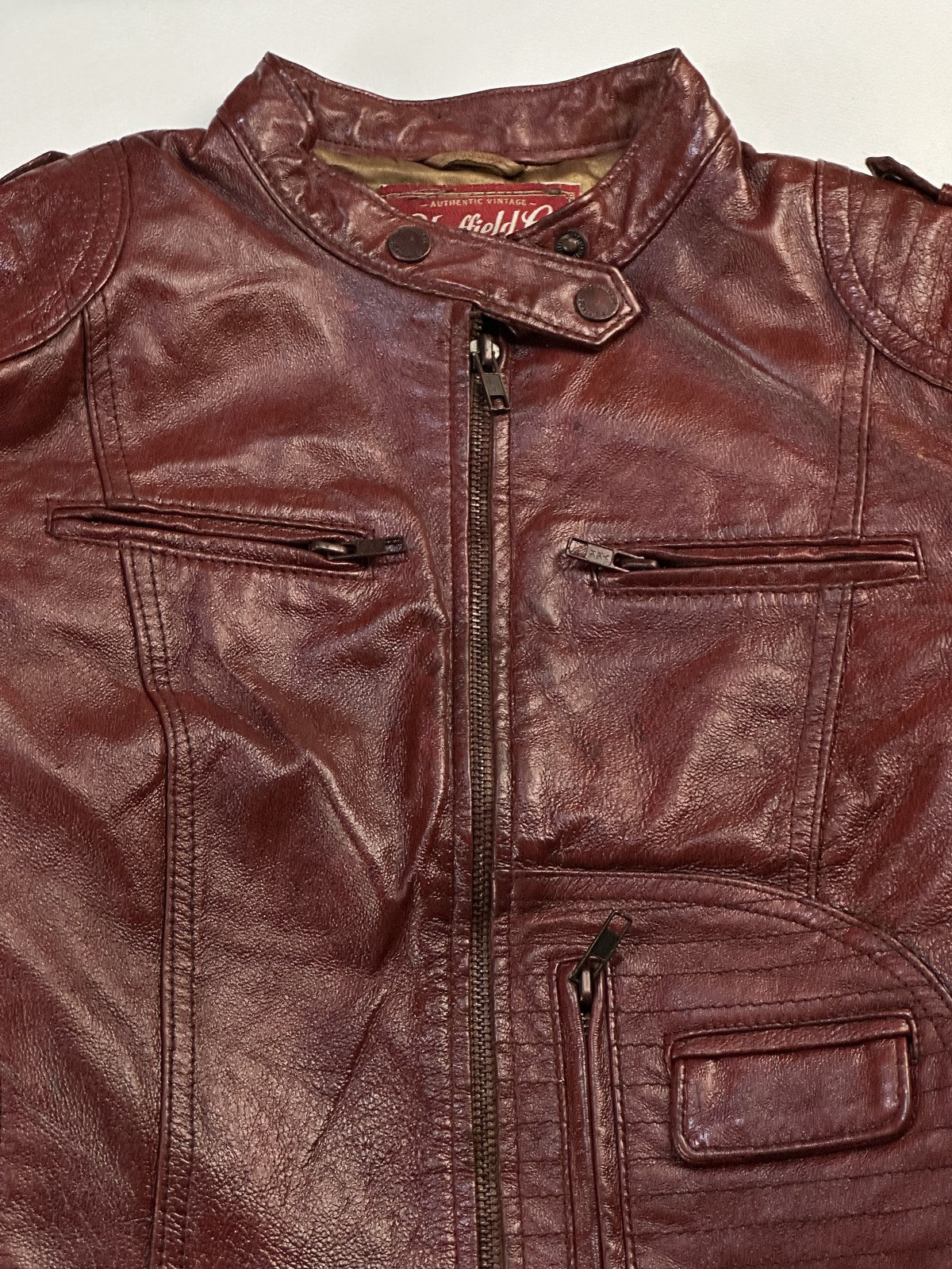 Collar and neckline of the burgundy leather cafe racer