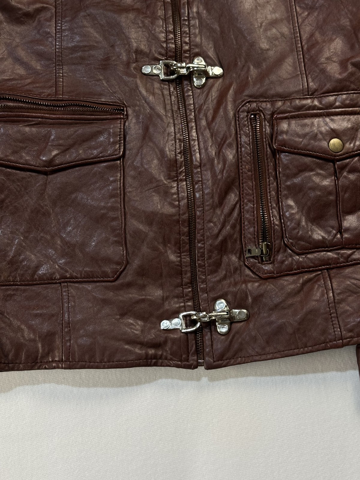 Close view of the leather grain and stitching on the burgundy jacket