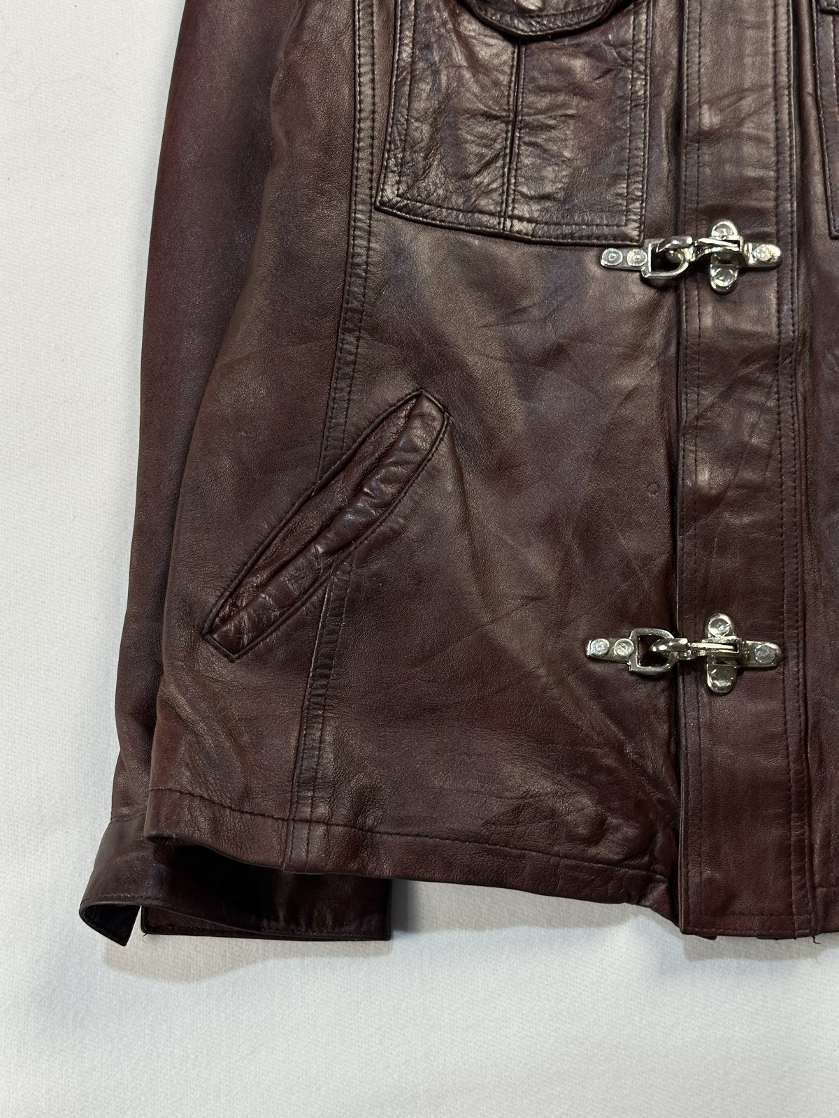Close view of the leather grain and stitching on the burgundy jacket