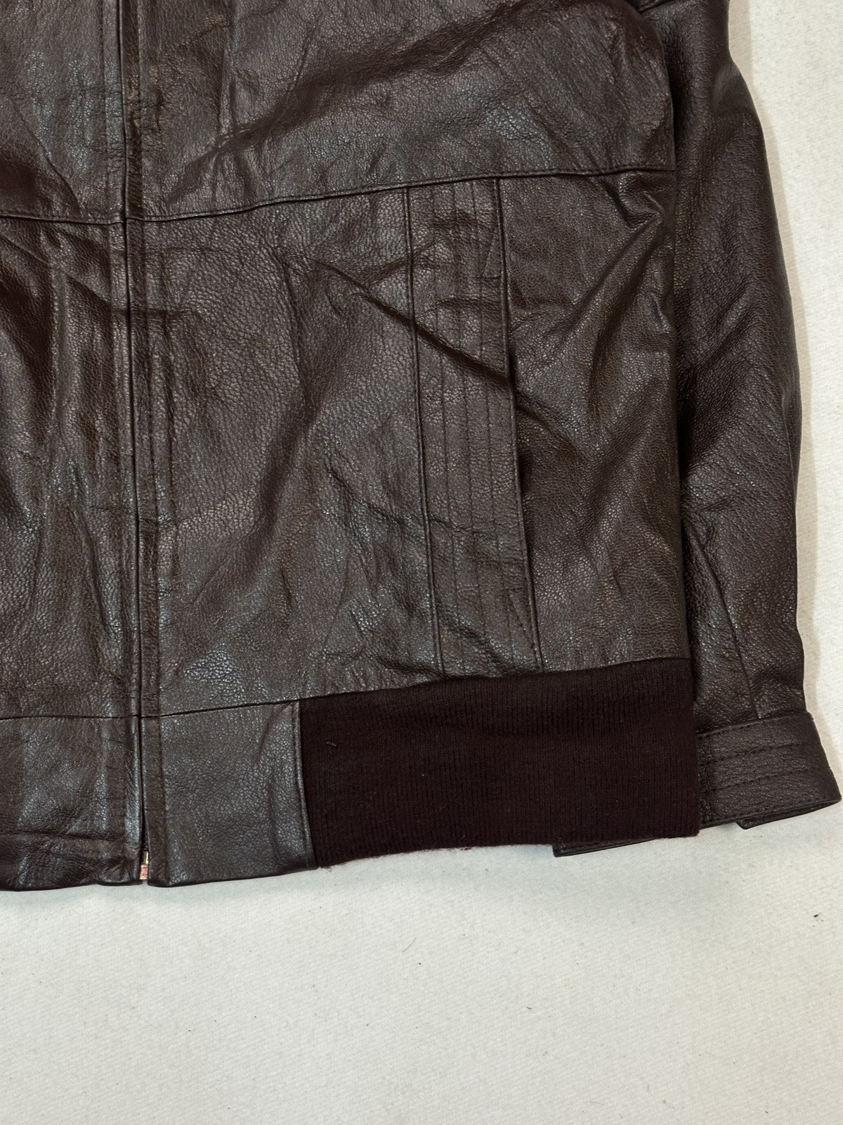 Detail of a ribbed cuff meeting the burgundy leather sleeve