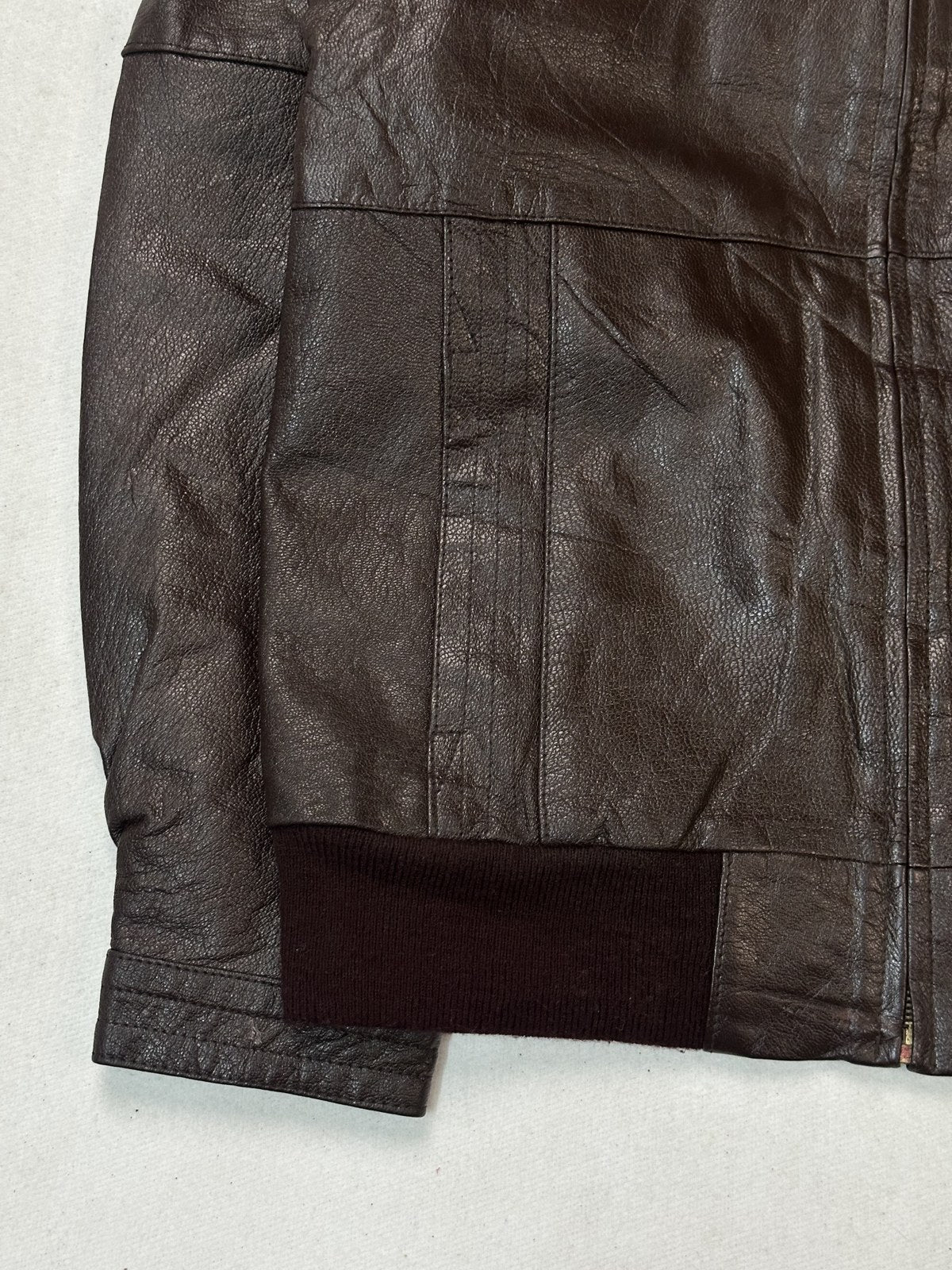 Cream lining shown inside the open burgundy leather flight jacket