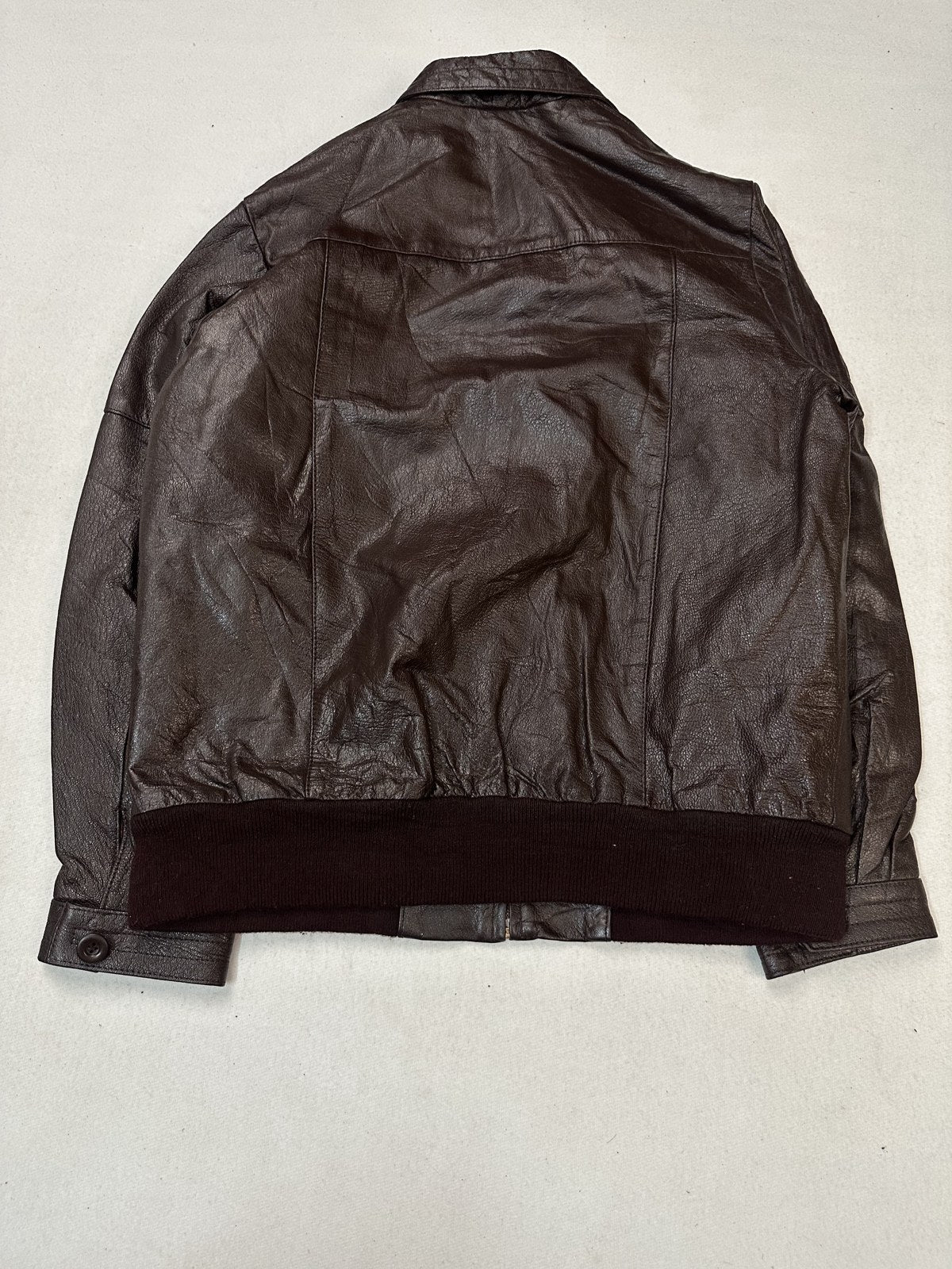 Back of the burgundy flight jacket showing how the rib waistband draws the hem in