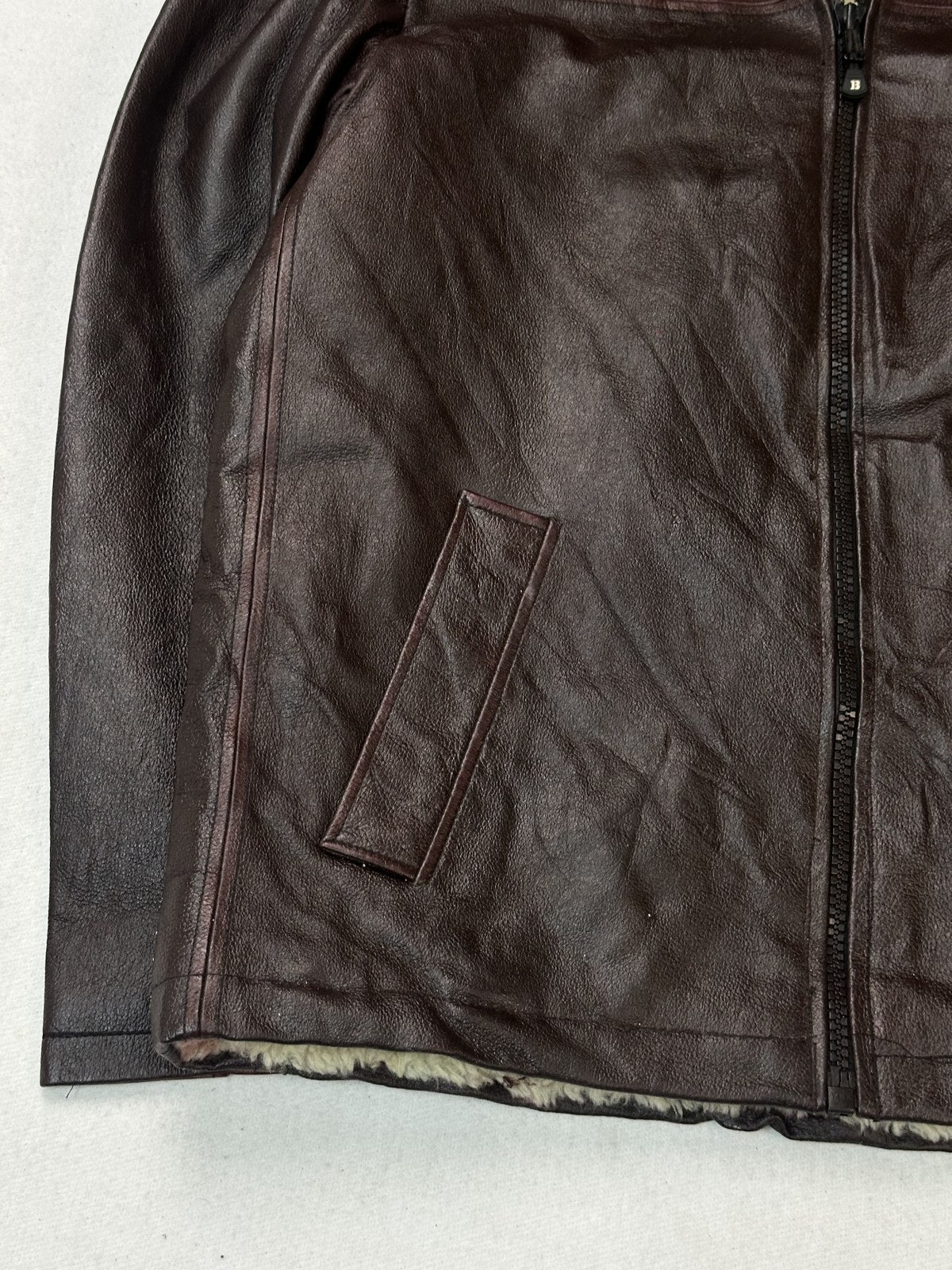 Cream shearling collar of the burgundy L flight jacket seen up close against the hide