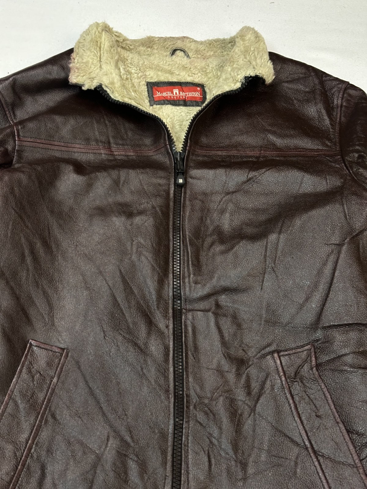 Front of a size L burgundy leather flight jacket with the cream shearling collar sitting flat