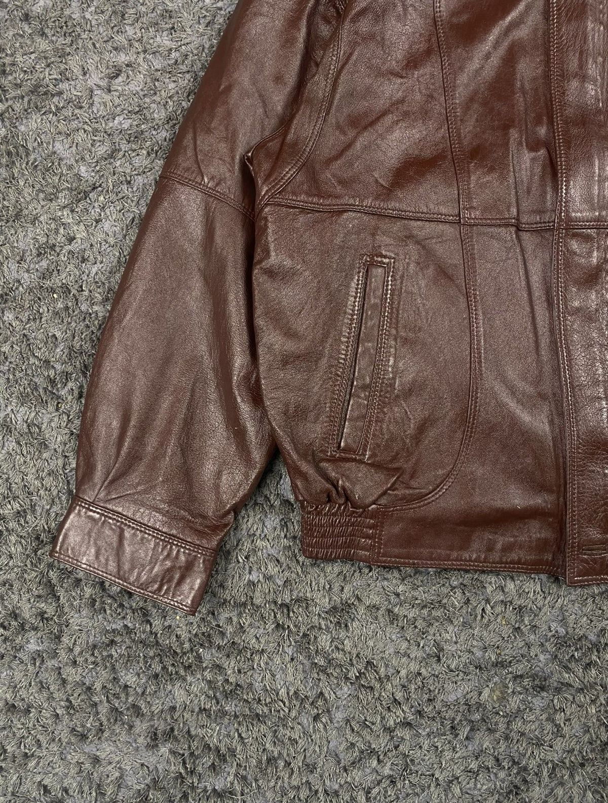 Ribbed cuff and sleeve detail on the dark burgundy flight jacket