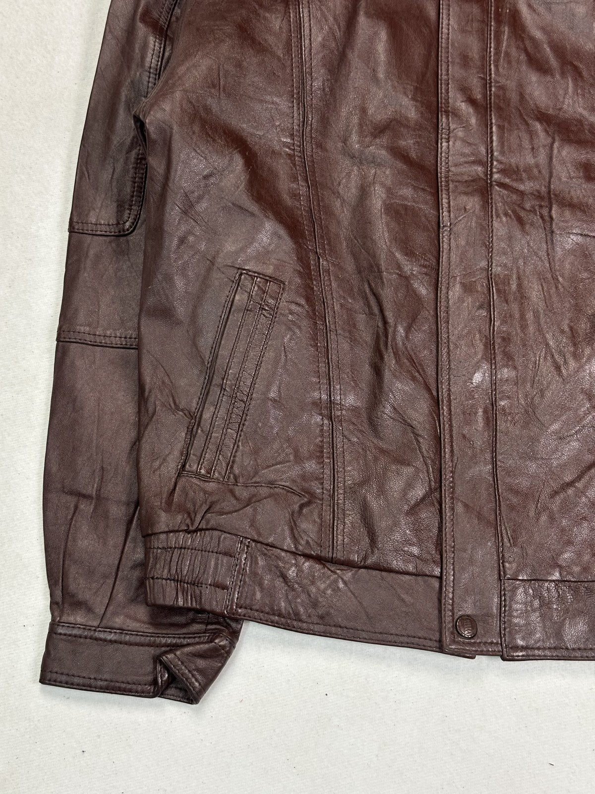 The shirt collar of the burgundy leather flight jacket, viewed closely
