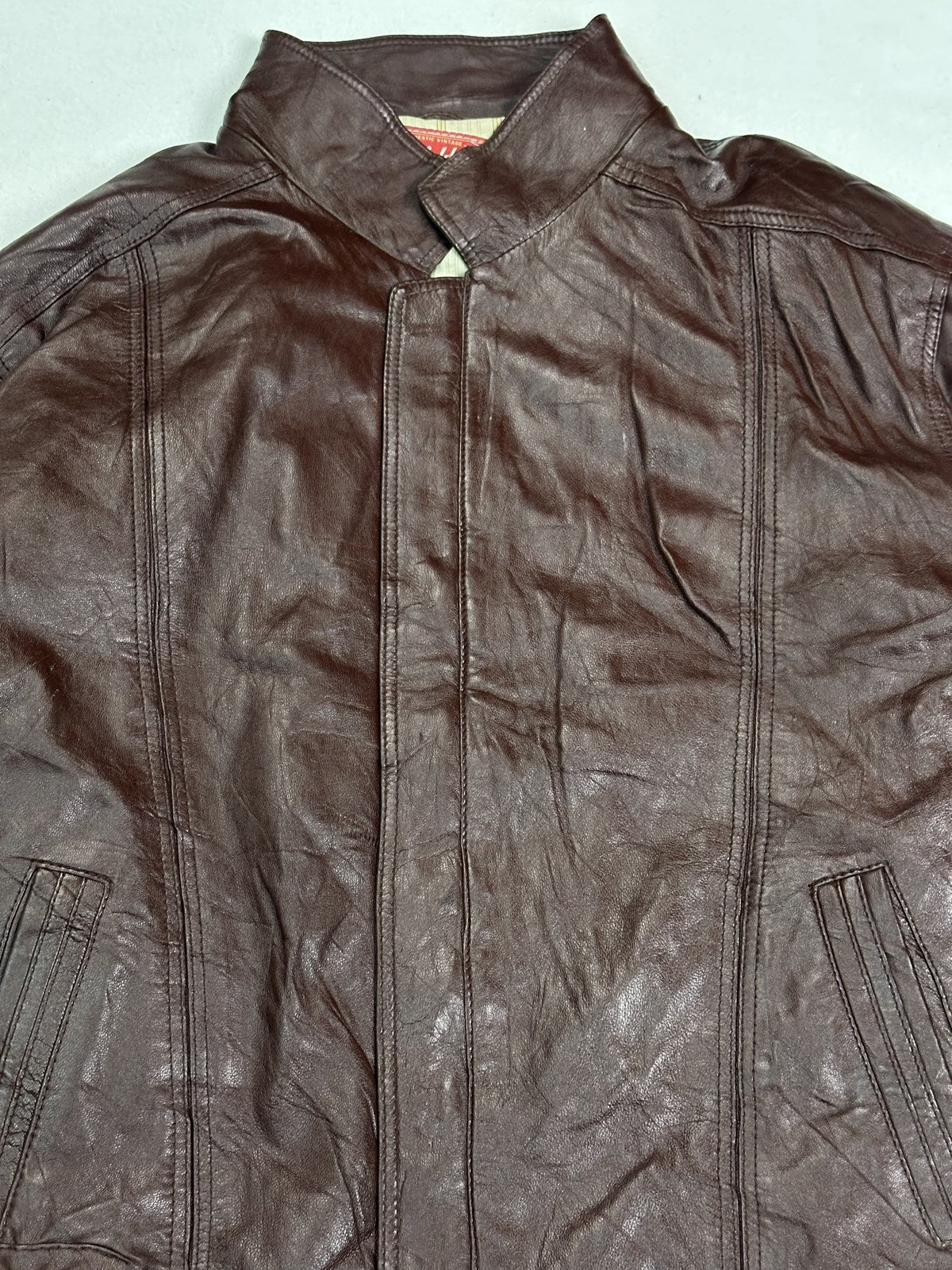 Closer frame of the front of the size L burgundy flight jacket, collar and zip in view