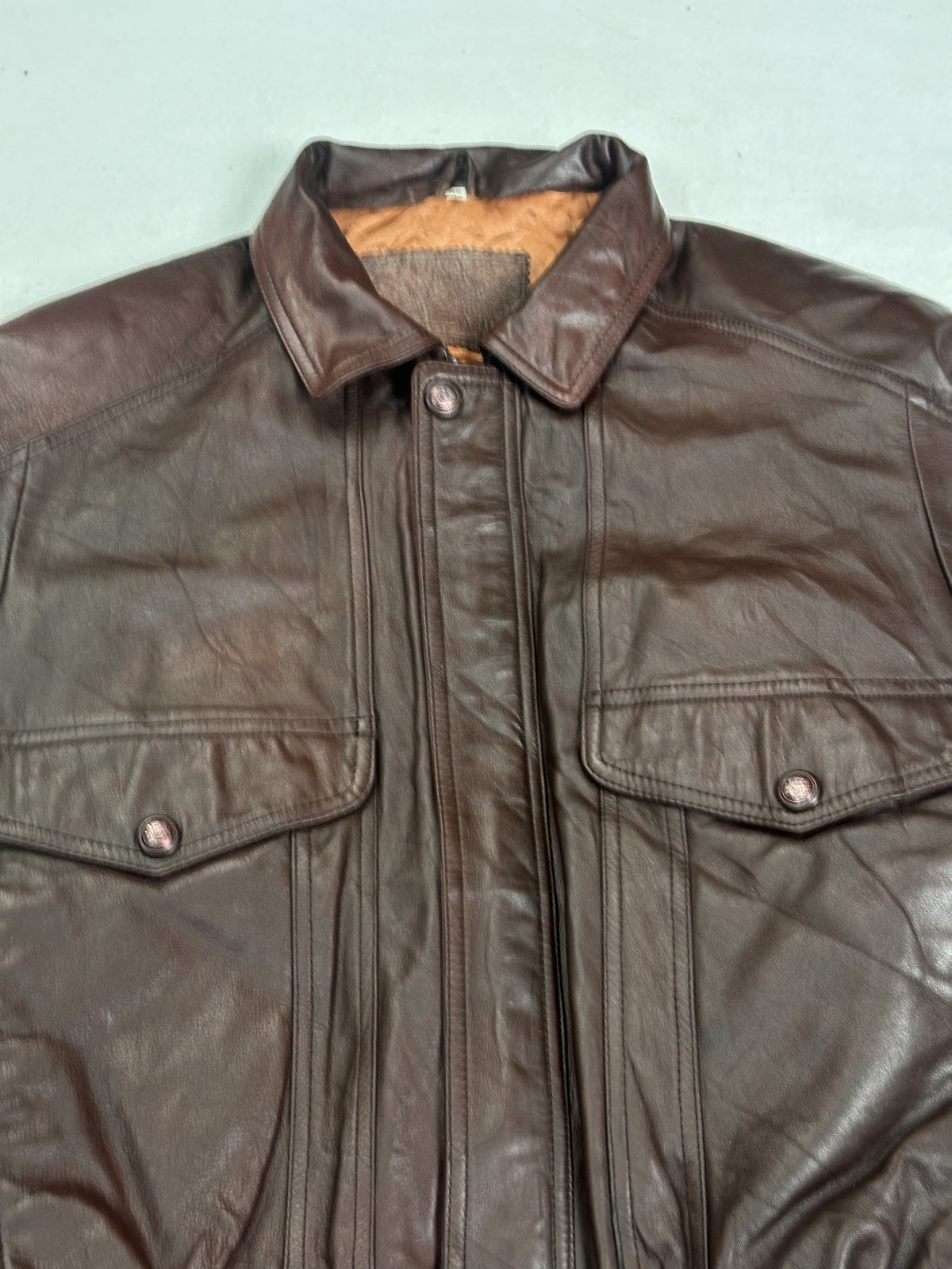 Close view of a chest flap pocket and its stitching on the burgundy flight jacket