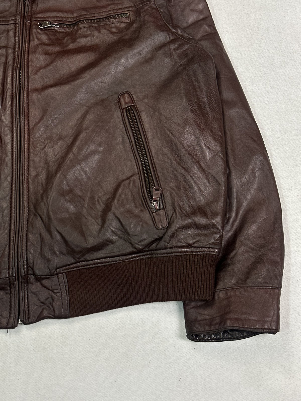Corduroy trim along the collar of the burgundy leather flight jacket