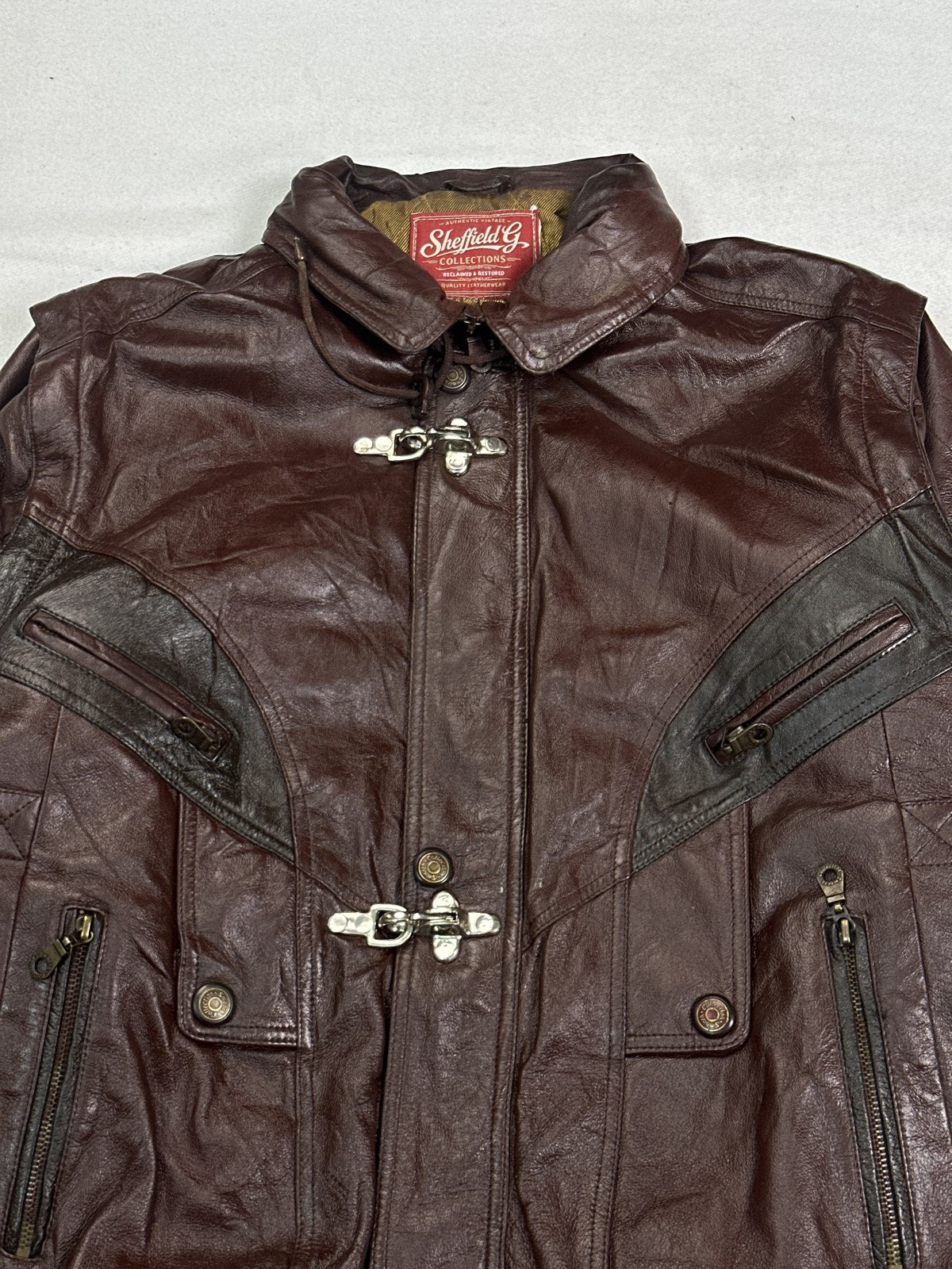 Collar and chrome clasp fastening on the burgundy harrington