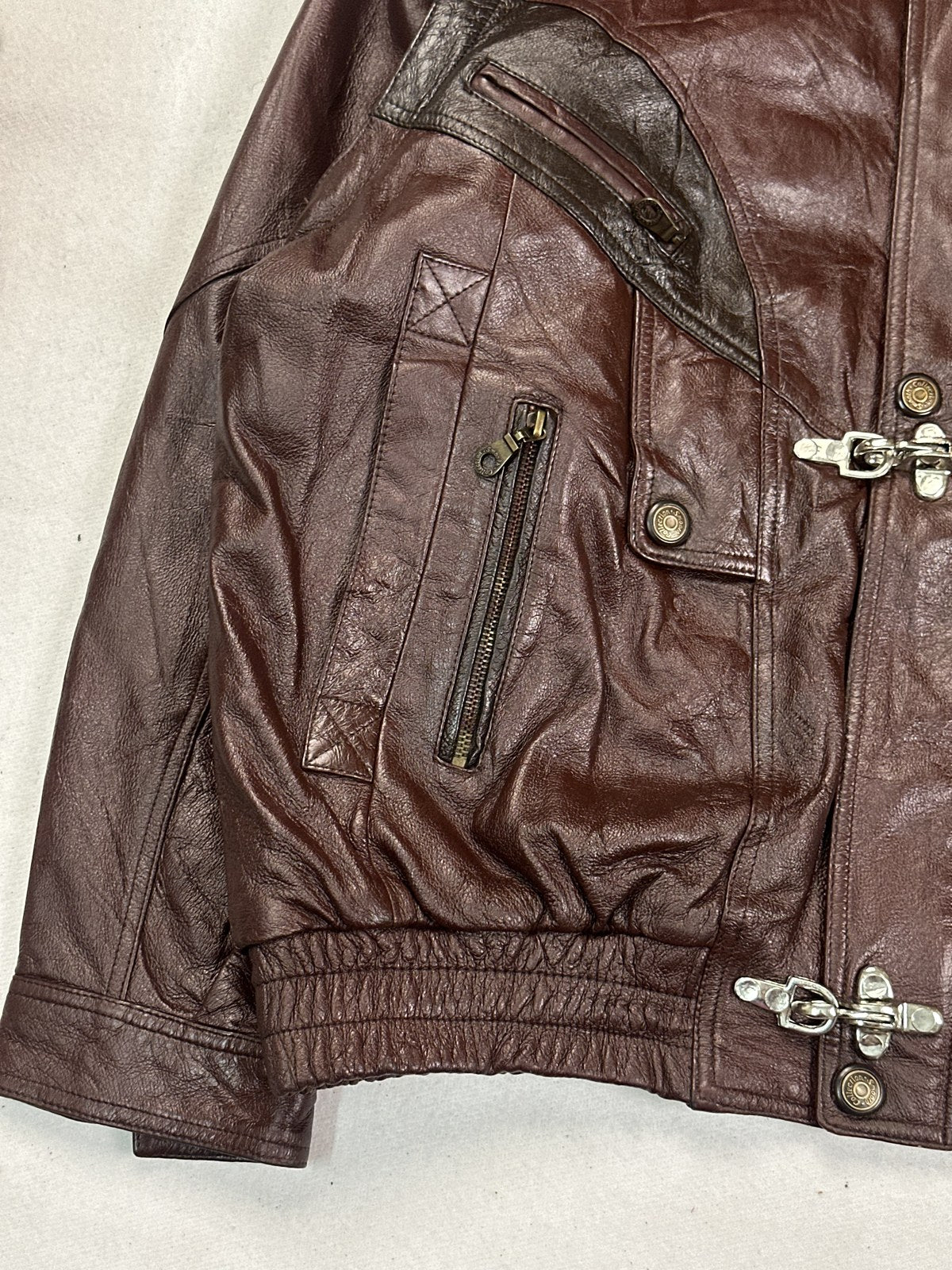 Close view of the leather grain and stitching on the burgundy jacket