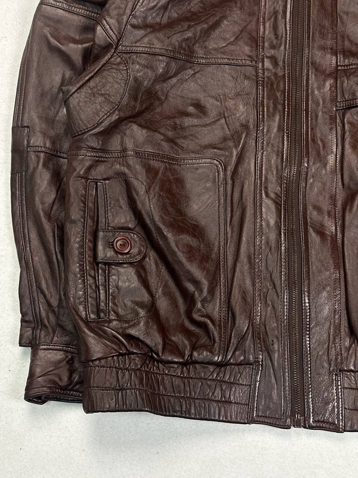 Close view of the leather grain and stitching on the burgundy jacket