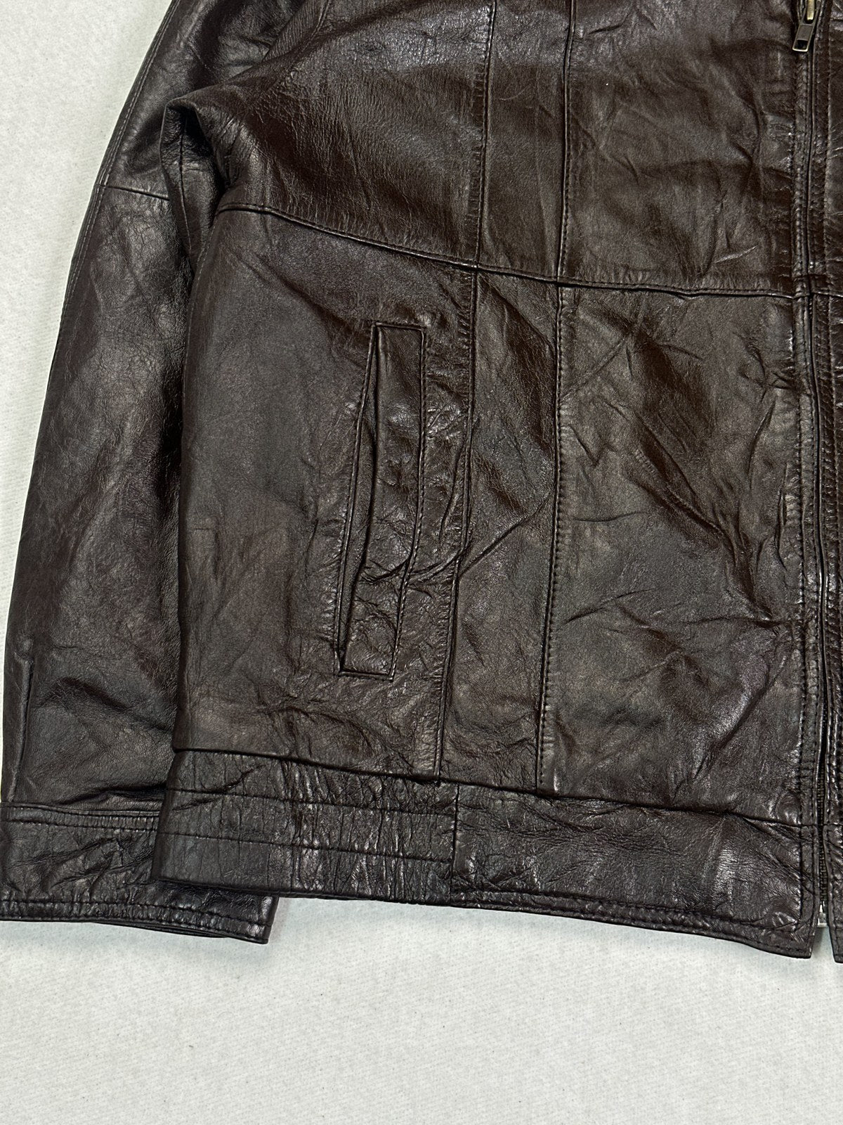 Close view of a vertical welt pocket and the burgundy leather grain