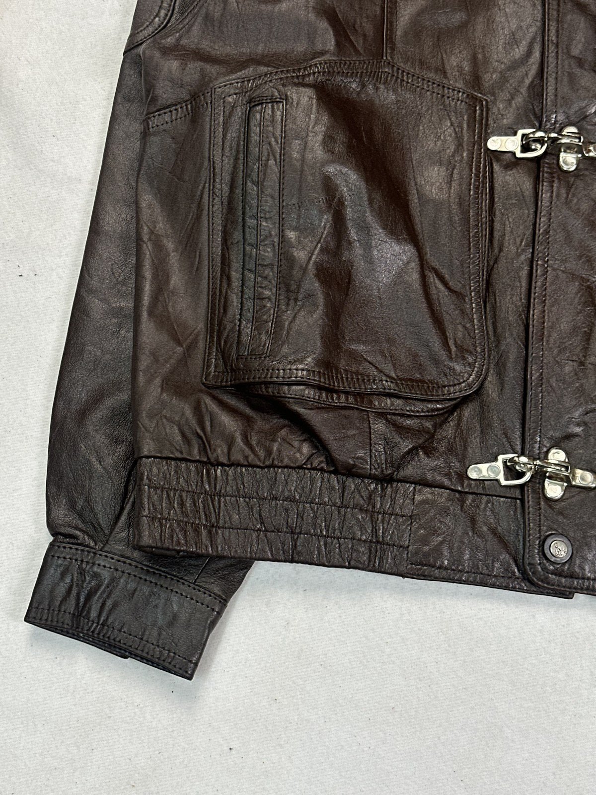 Close view of a zipped welt pocket and the burgundy leather grain