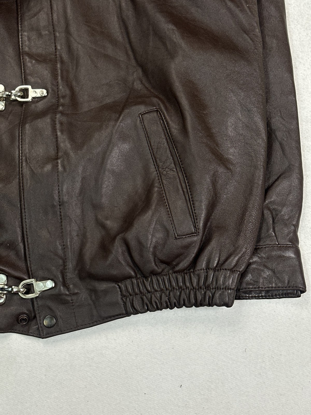 Close view of the leather grain and stitching on the burgundy jacket