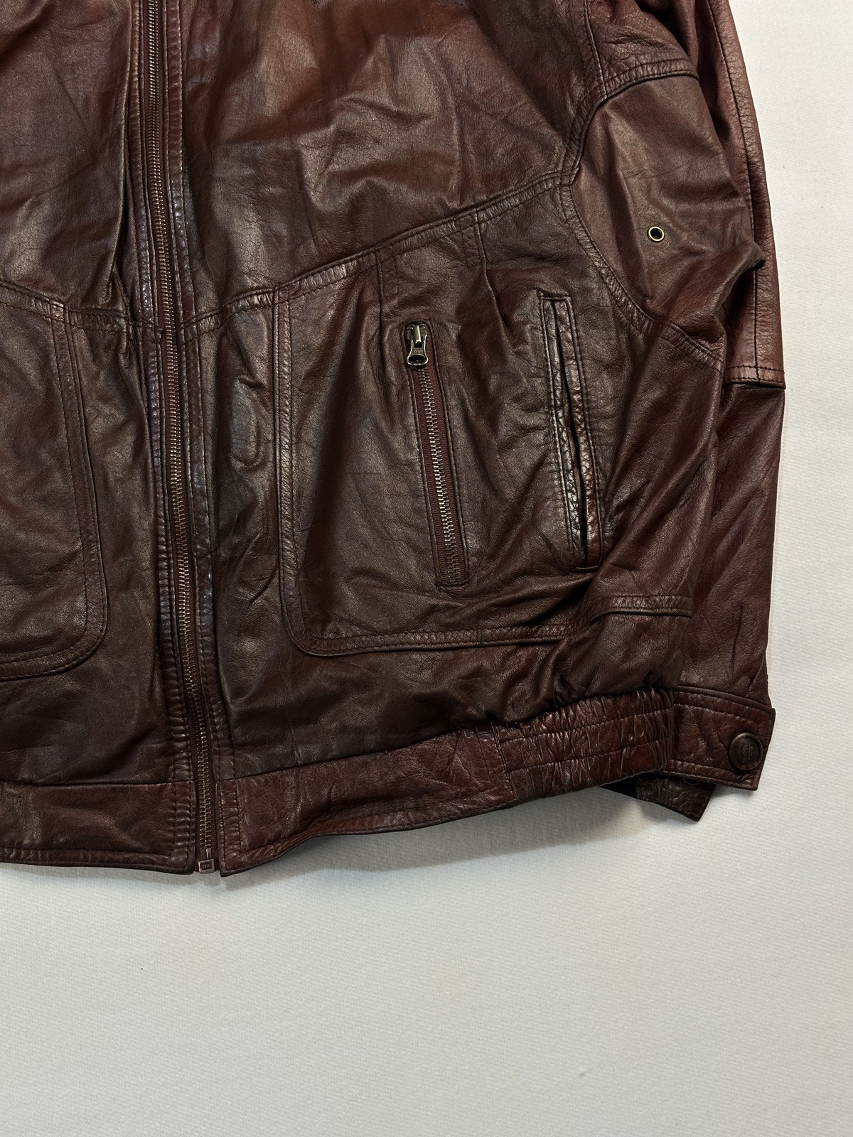 Close view of the leather grain and stitching on the burgundy jacket