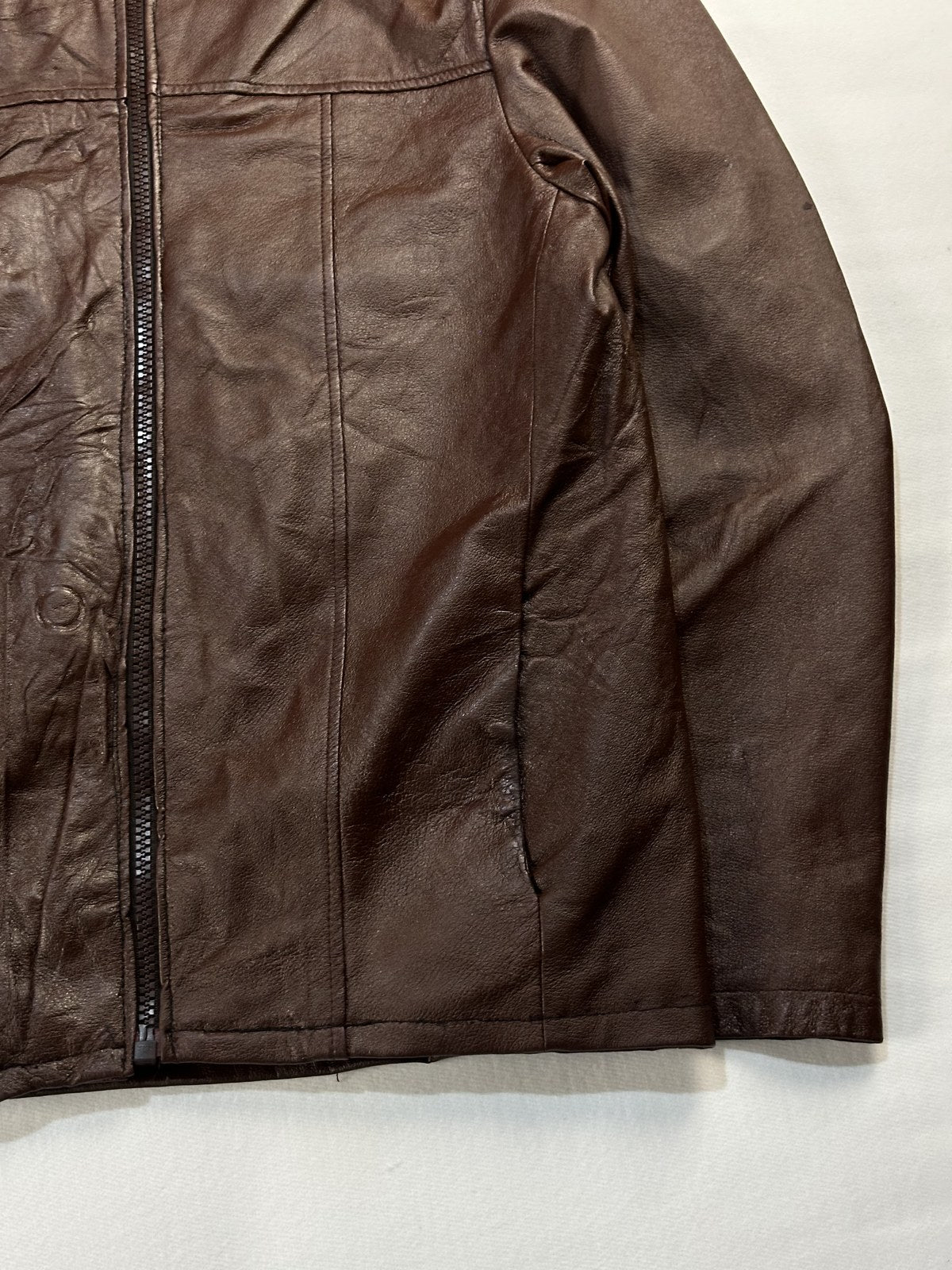 Close view of the leather grain and stitching on the burgundy jacket