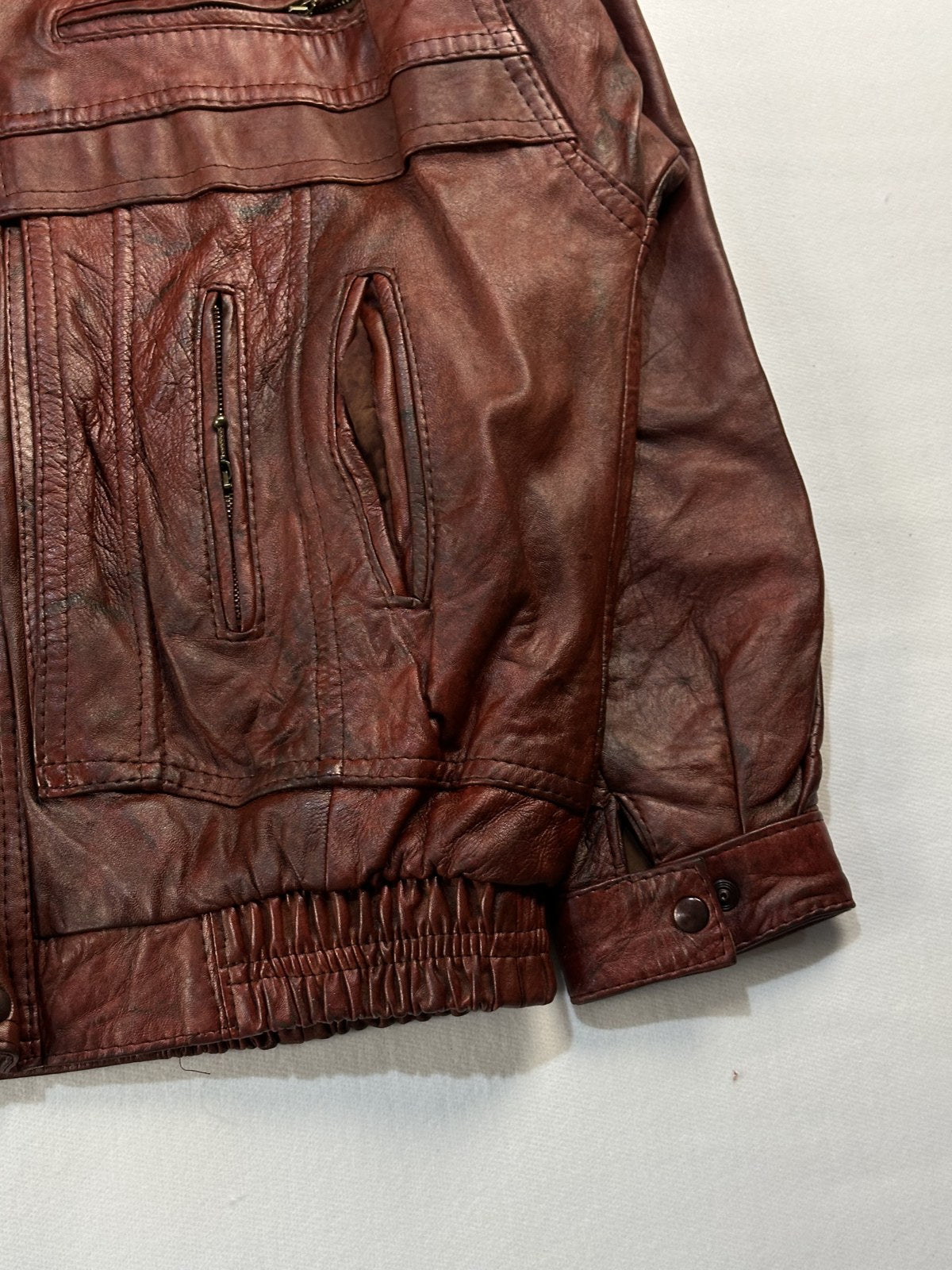 Close view of the leather grain and stitching on the burgundy jacket