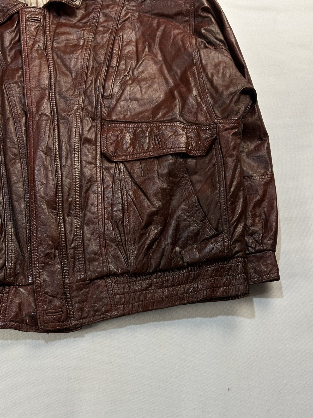 Close view of the leather grain and stitching on the burgundy jacket
