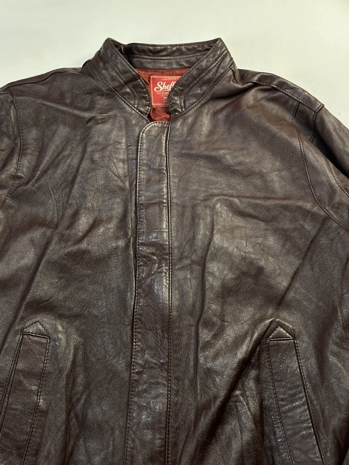 Collar above the concealed zip placket on the burgundy harrington