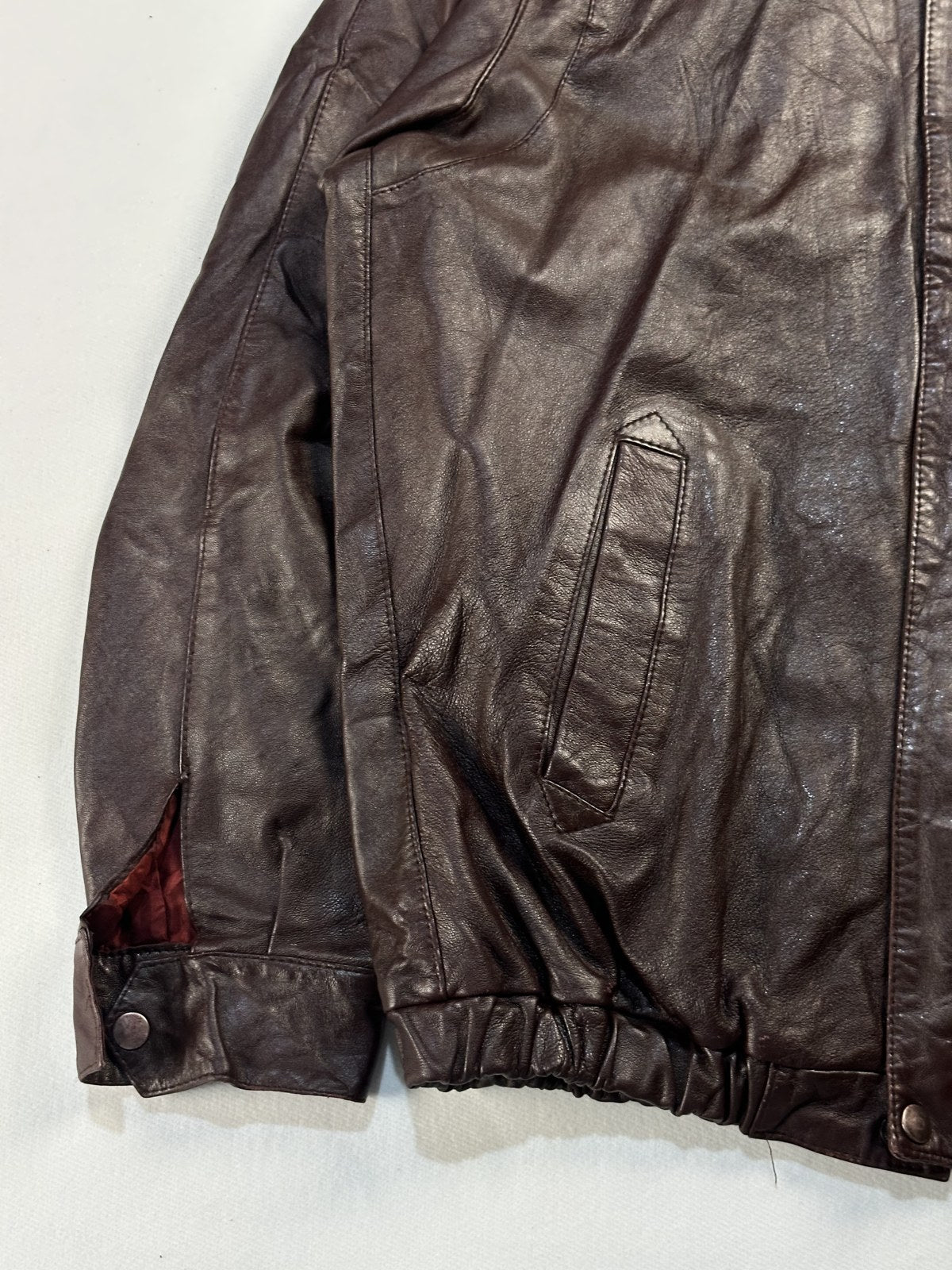 Close view of the leather grain and stitching on the burgundy jacket