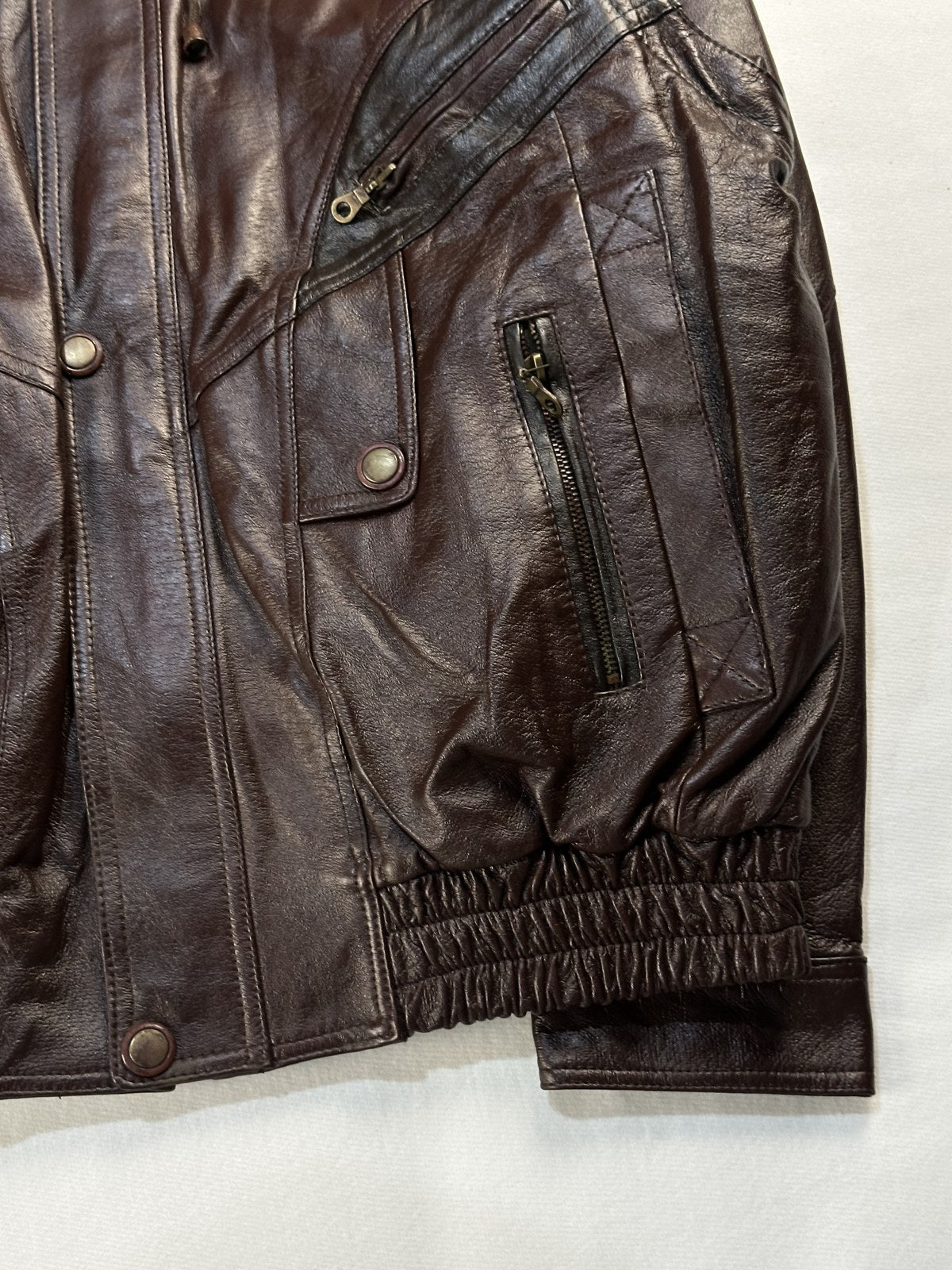 Close view of the leather grain and stitching on the burgundy jacket