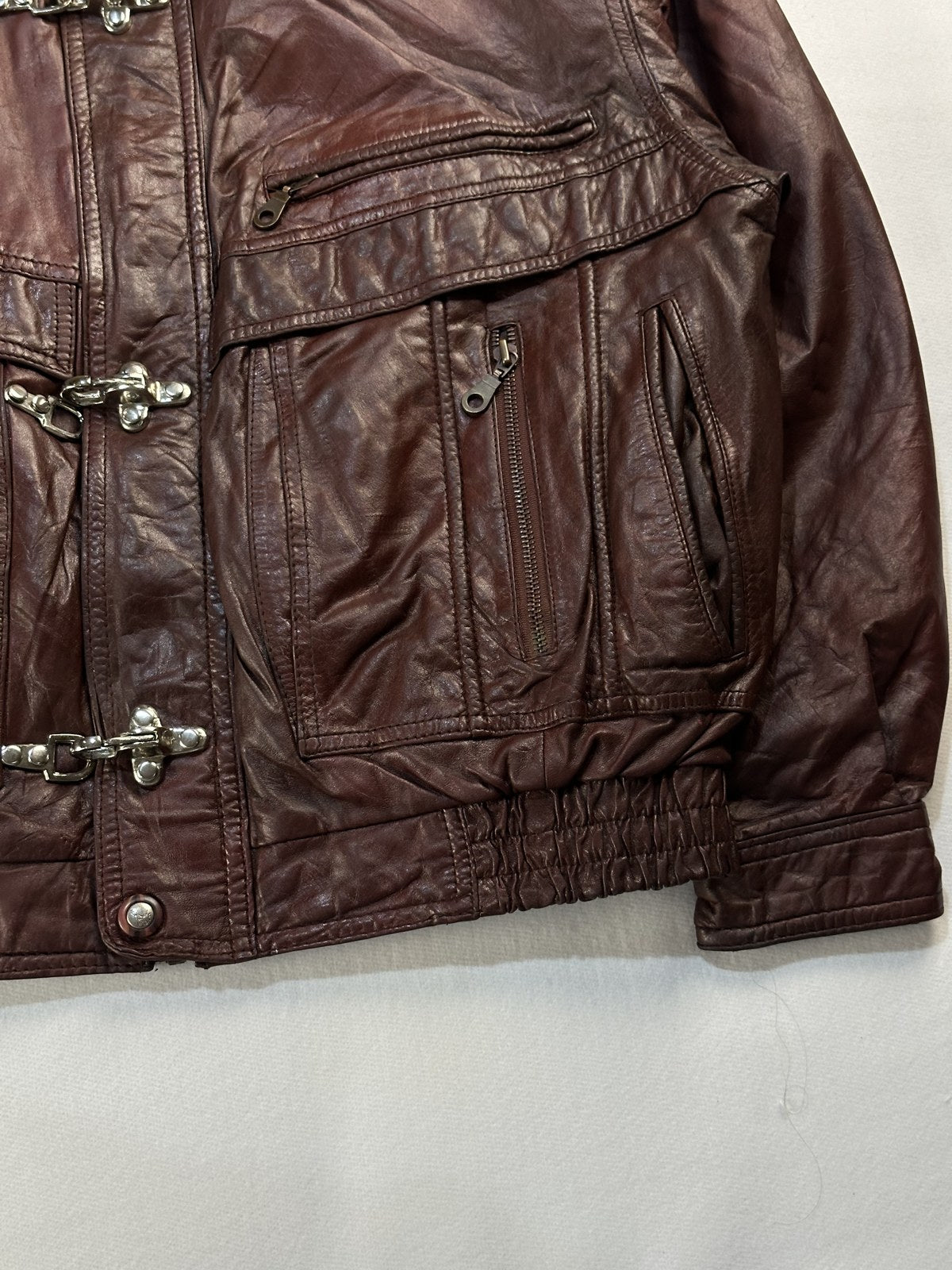 Close view of the leather grain and stitching on the burgundy jacket