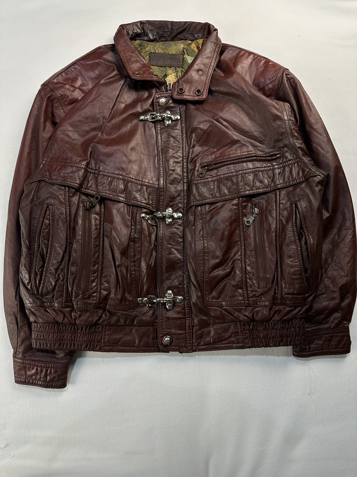 Burgundy leather harrington jacket in size XL laid flat from the front