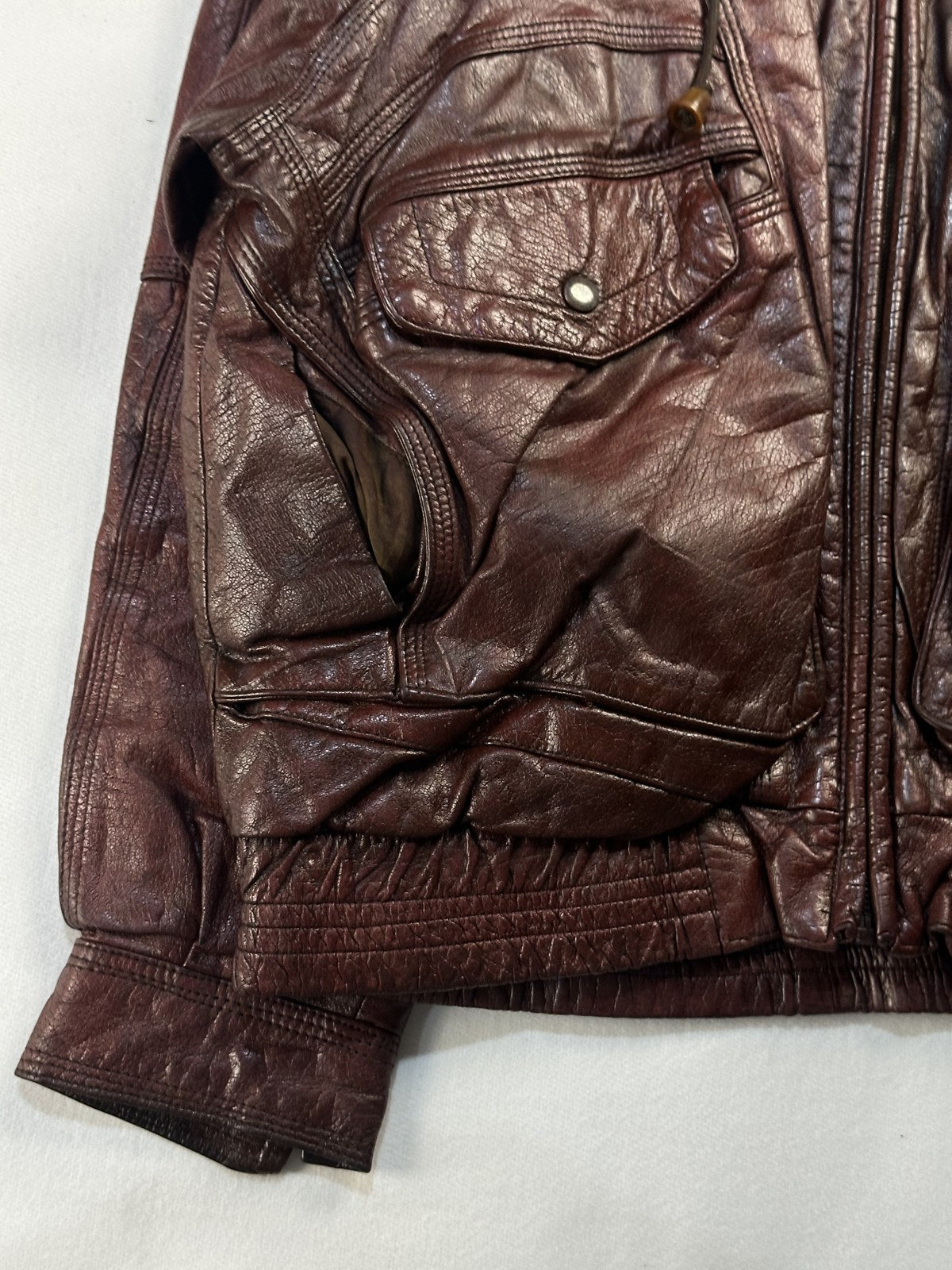 Close view of the leather grain and stitching on the burgundy jacket