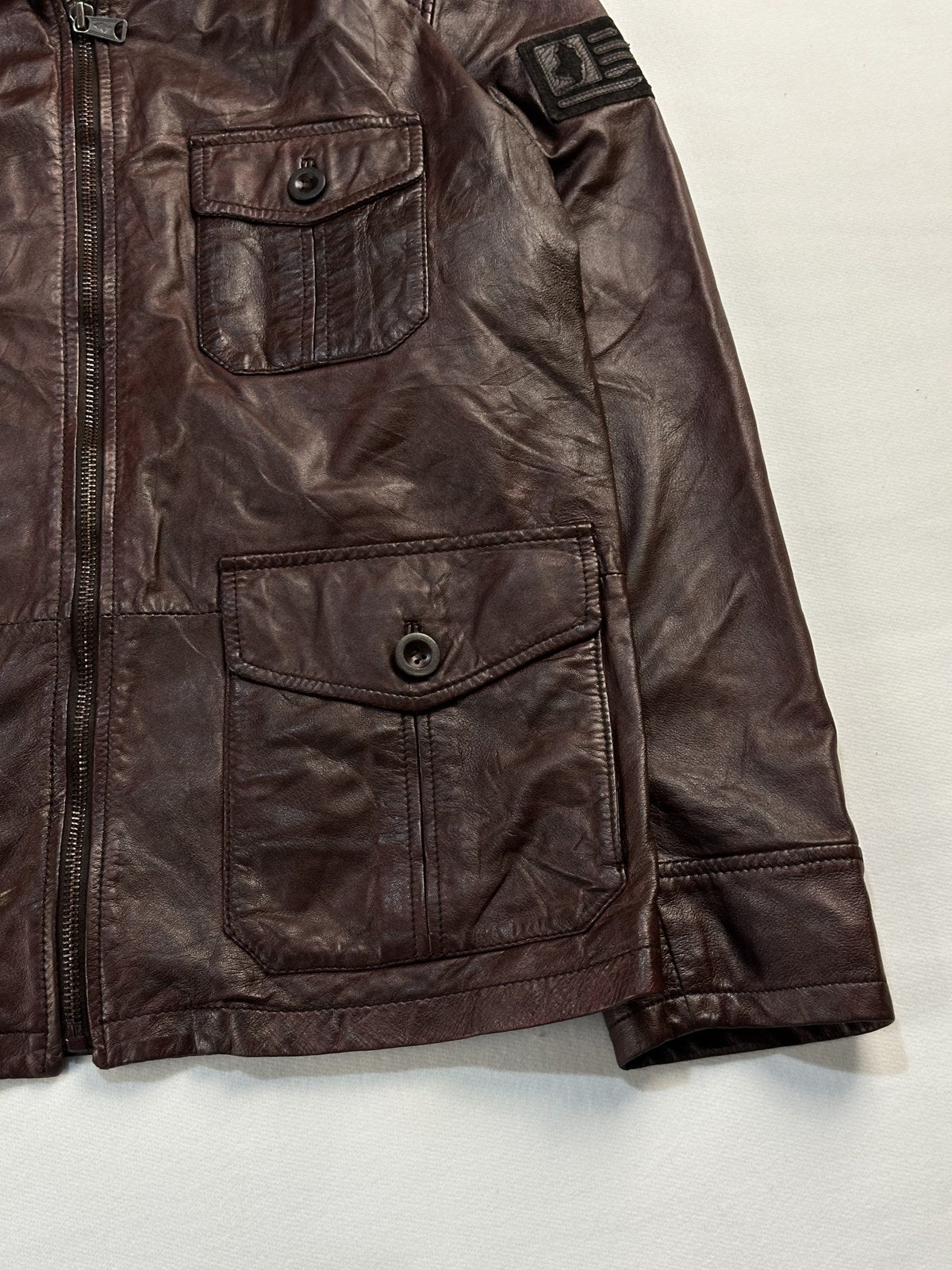 Close view of the sleeve flag patch and the burgundy leather grain