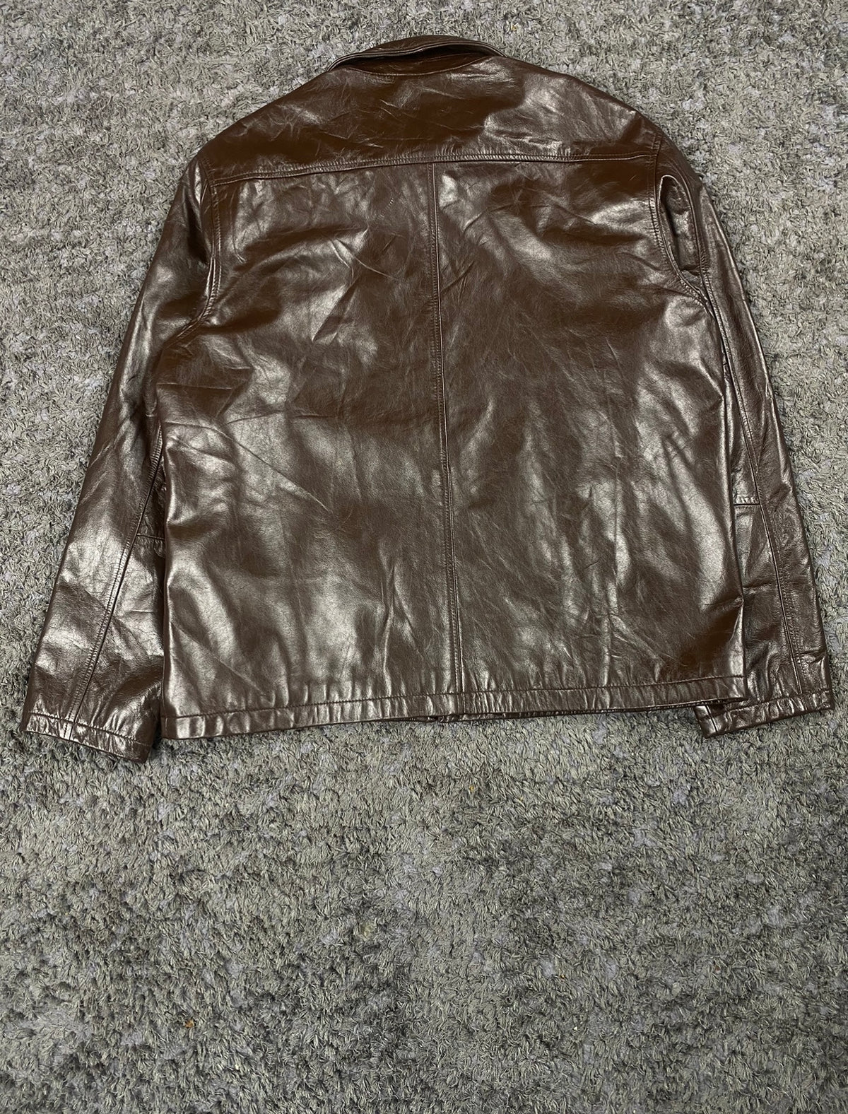 Pointed collar at the neck of the brown leather harrington