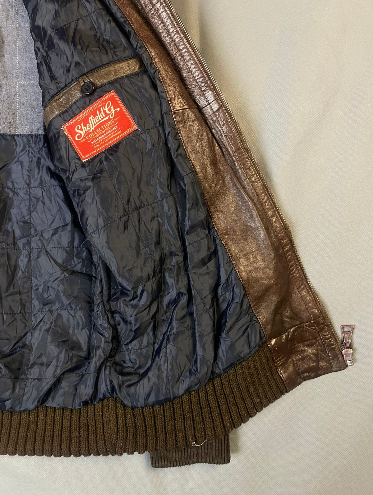 Detail of the navy inner lining and inside pocket above the ribbed hem