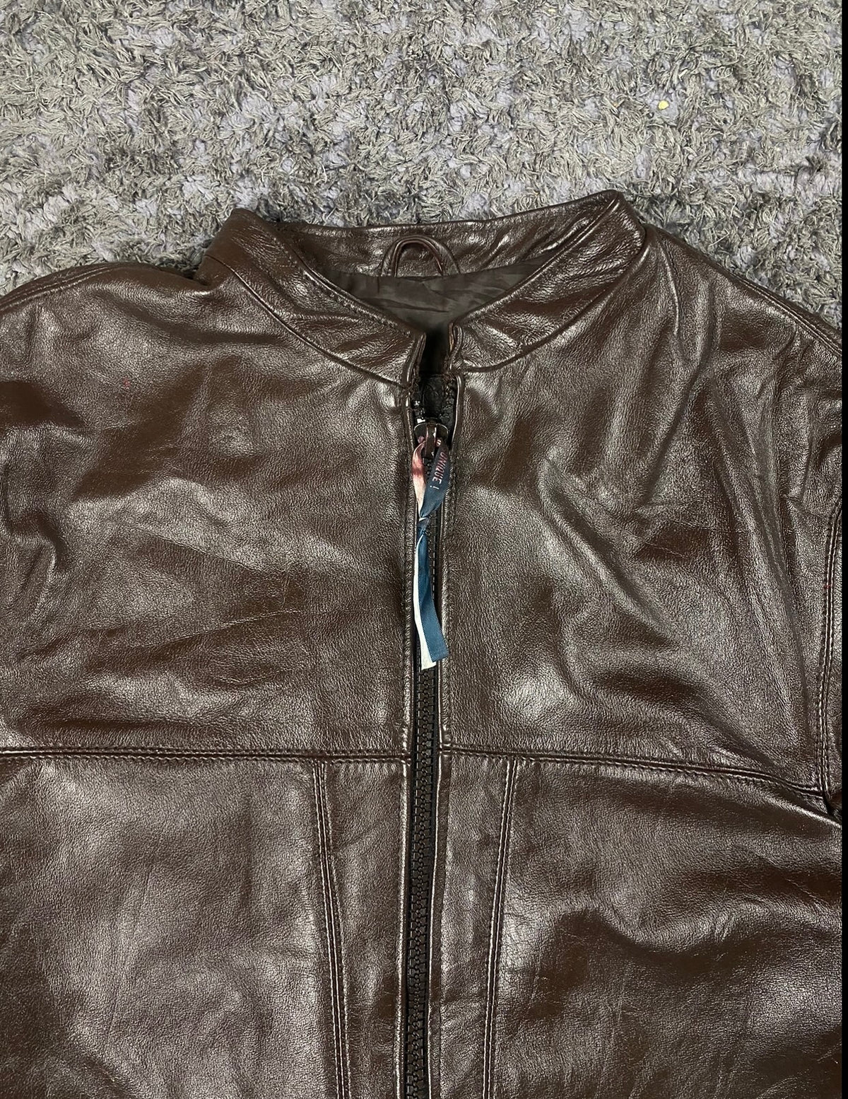 Close view of the band collar and the striped tape behind the top of the zip