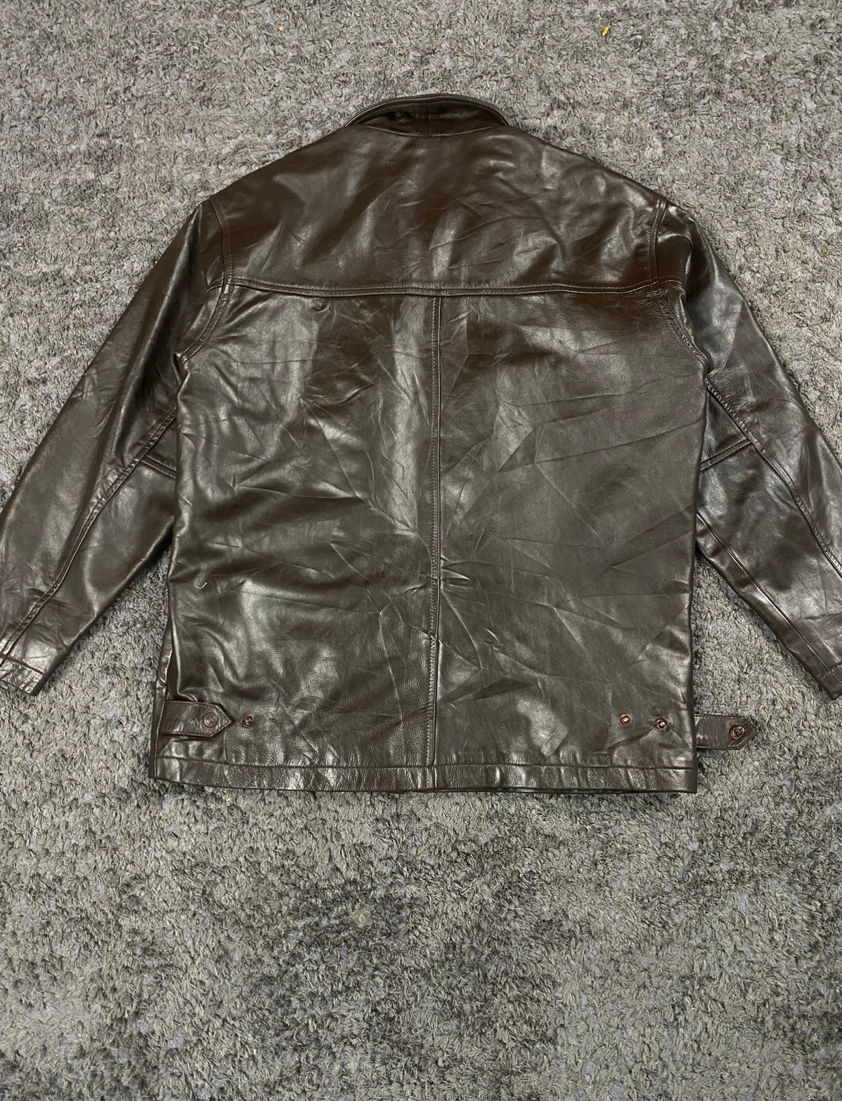 Back of the XL brown jacket showing the plain leather panel and side waist tabs