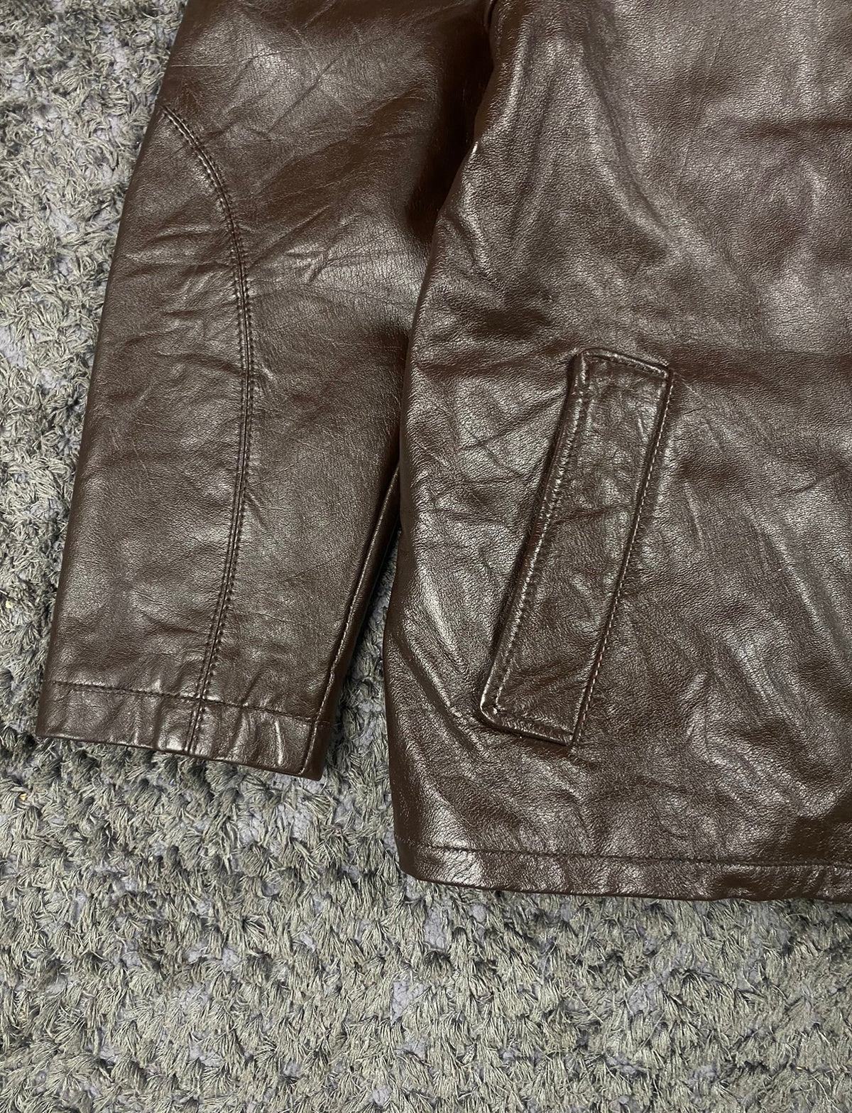 Welt hip pocket, plain cuff and straight hem on the brown leather jacket